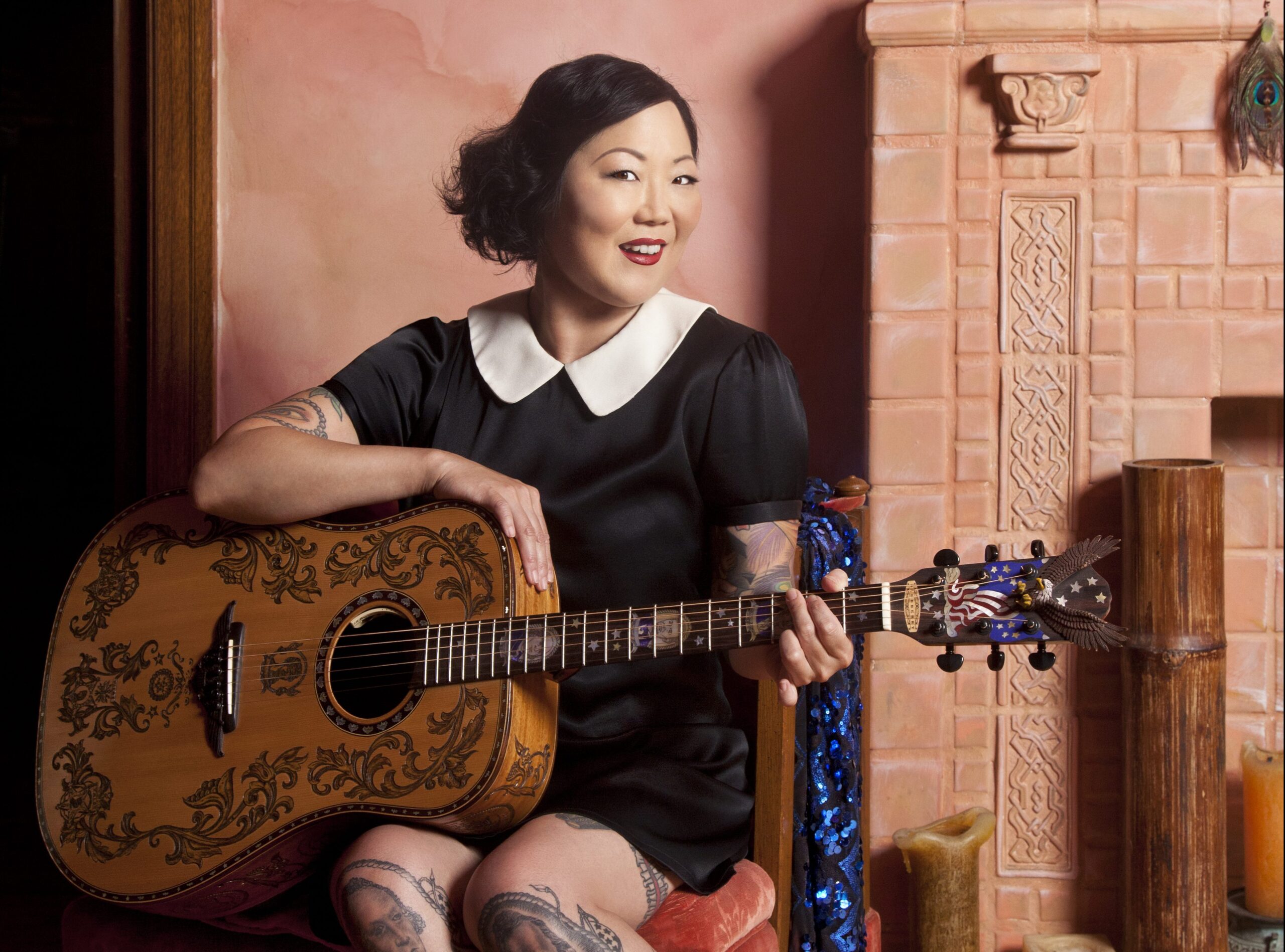 Margaret Cho sitting with a guitar.