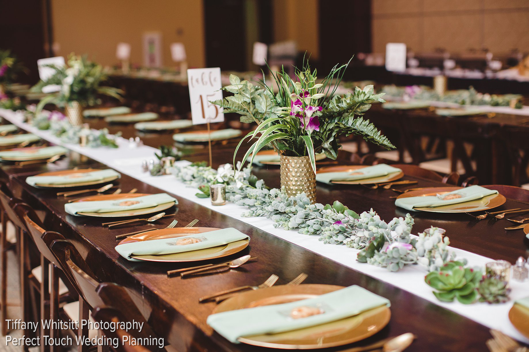 A photo of a wedding banguet in the Canyon West Ballroom at The Lincoln Center. The plates are cold, and the table is decorated with purple and green succlents.