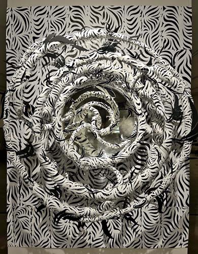 Paper sculpture with black and white patterned background and floating rings
