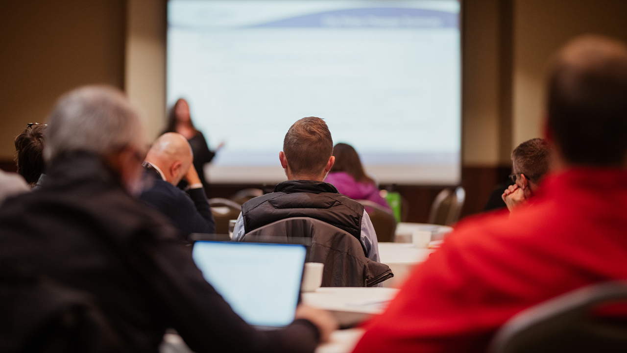 Individuals sitting at a business conference.