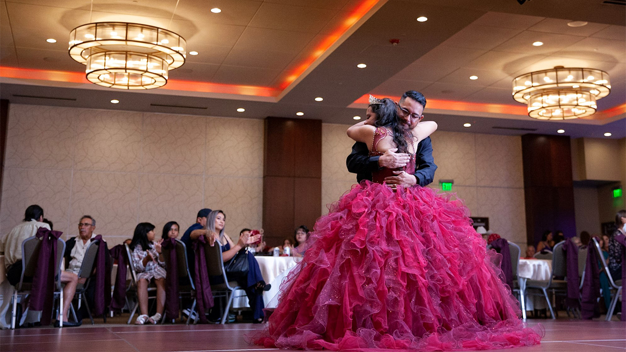 A father and daughter dance at a quinceañera.
