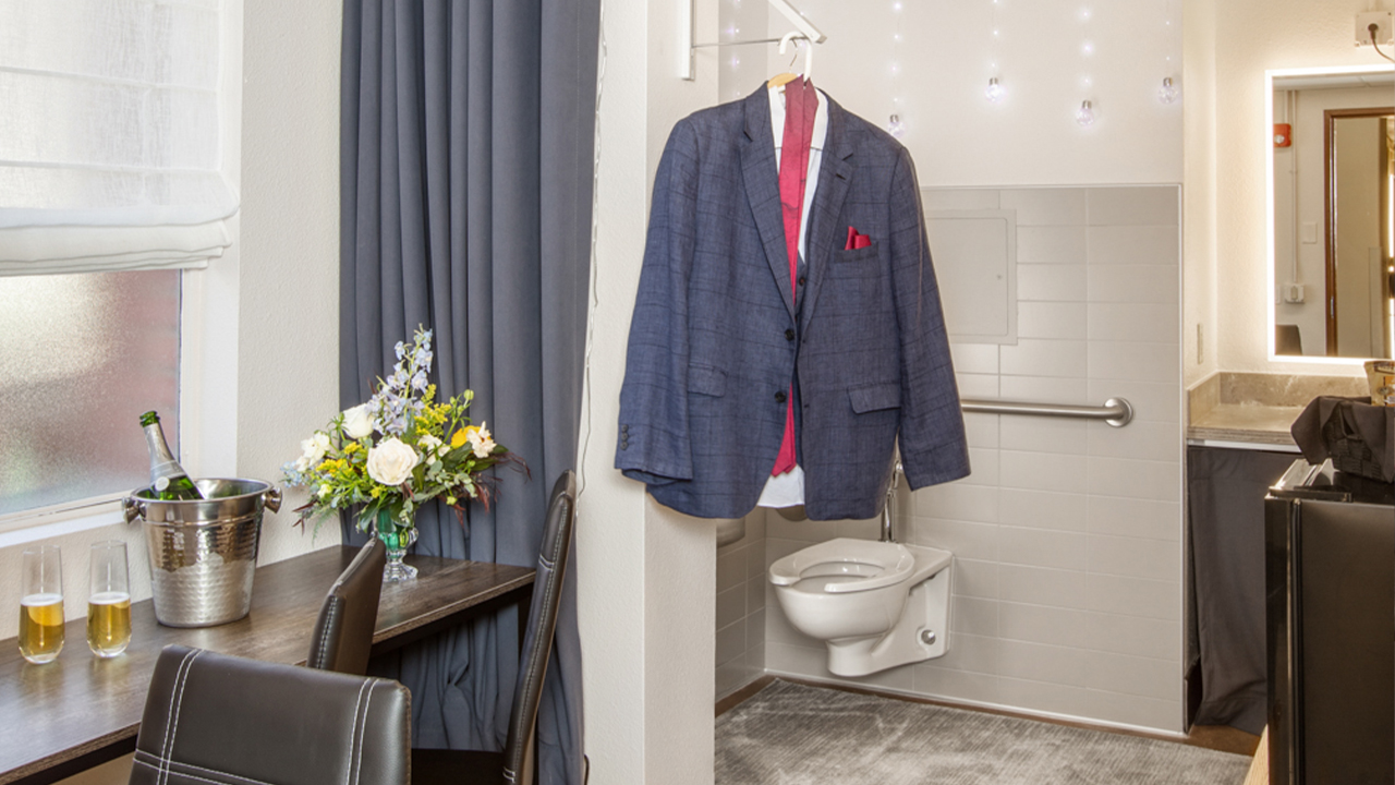 A suit hangs next to two glasses of champagne in the Changing Suite.