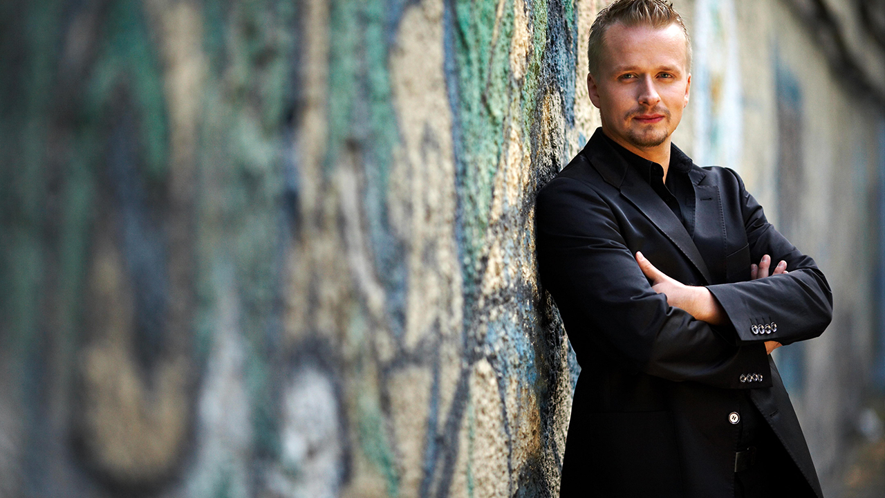 Ilya Yakushev leaning against a graffitied wall.