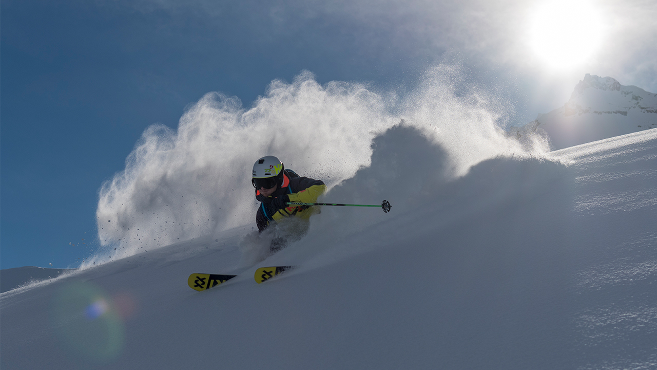 Man in snow gear skiing intensely down a mountain.