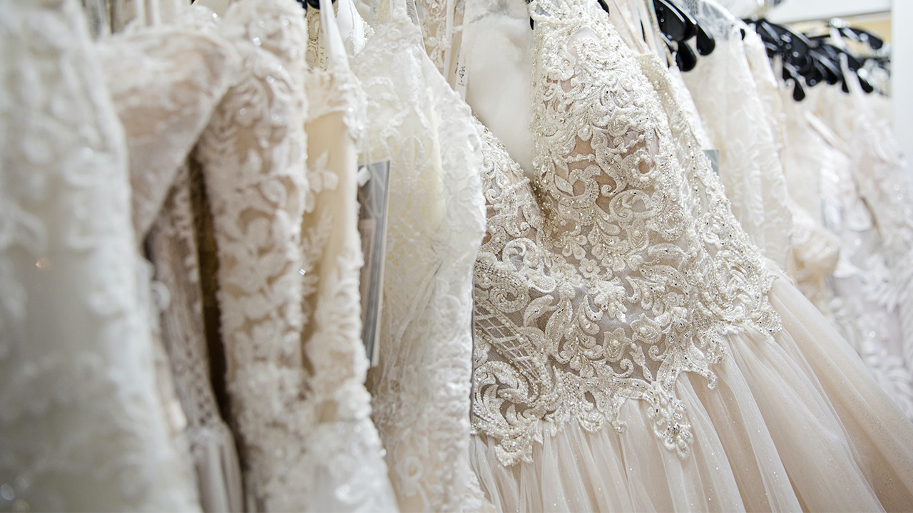 Wedding dresses hanging from rack.