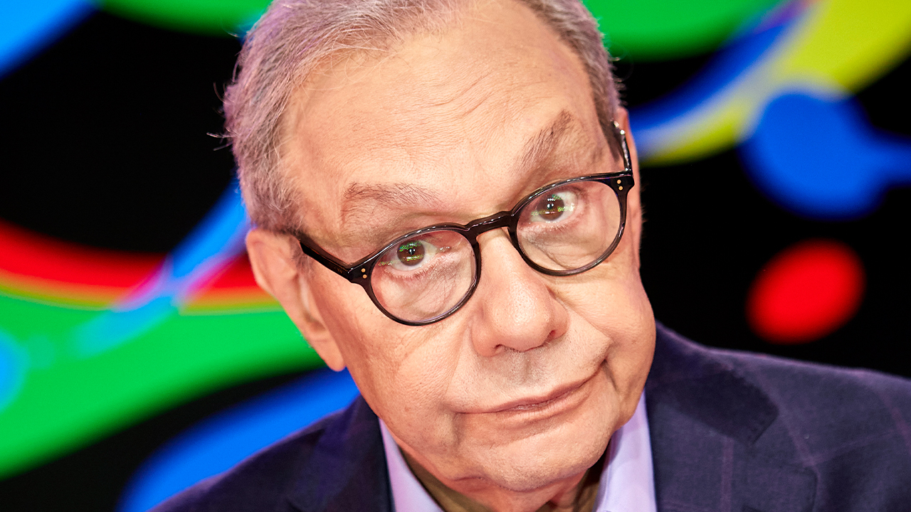 Lewis Black in front of a psychodelic background.