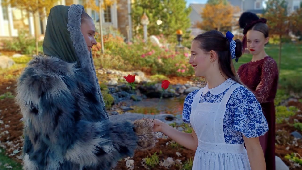 2 girls offering each other friendship roses while a mean girl pinches her face in the background.