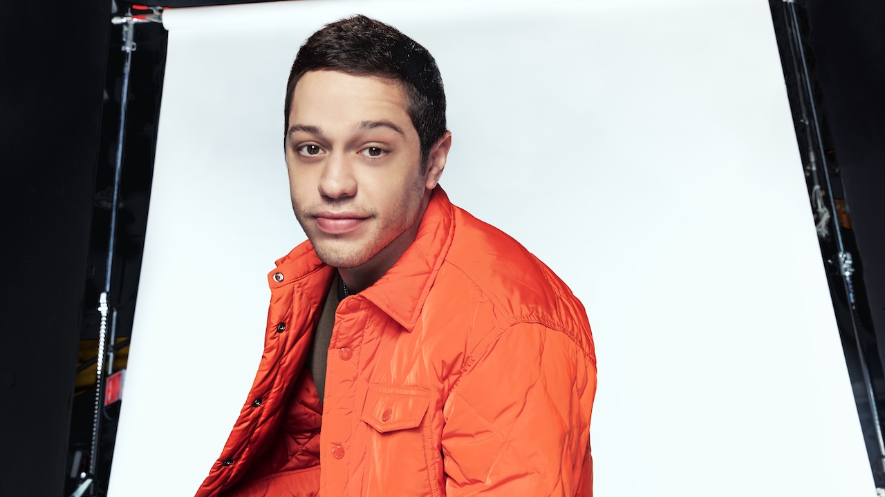 Pete Davidson wearing orange looking at camera