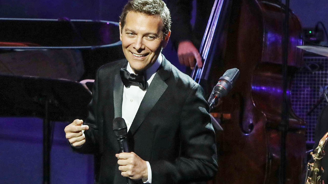 Micheal Feinstein smiling in a tuxedo on stage.