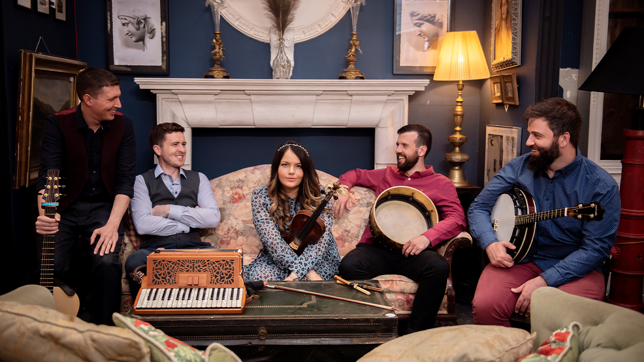 The group members of Goitse sit on a couch together with their instruments