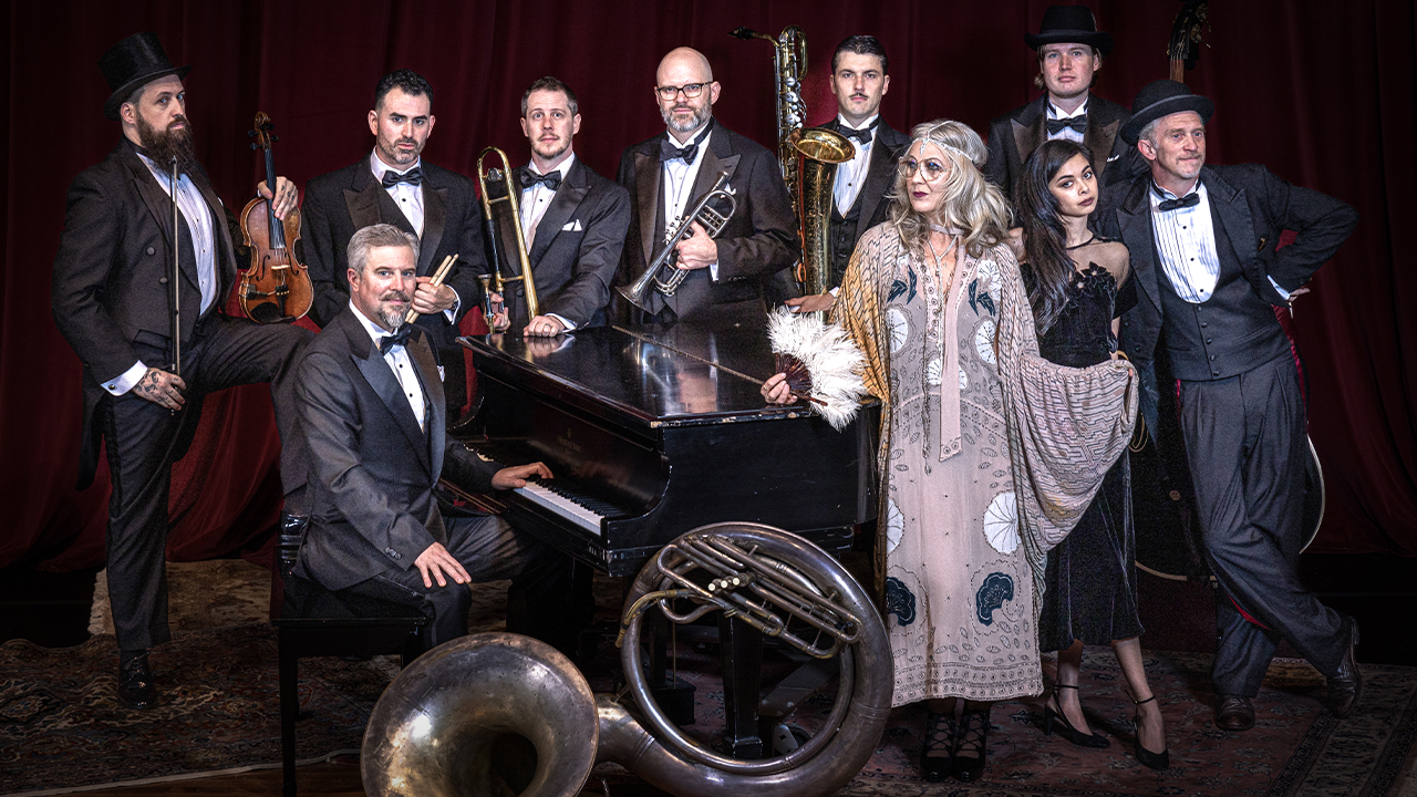 The band Squirrel Nut Zippers poses in black tie with their instruments