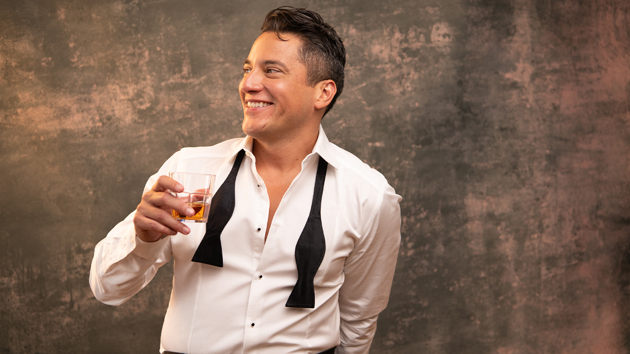 Nicholas Rodriguez poses for a picture with a whiskey glass