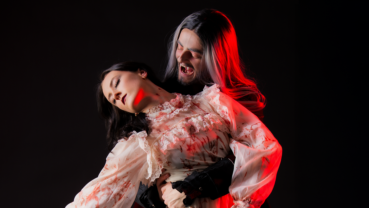 Ballet dancer Dracula leaning into bite the neck of a ballet dancer.