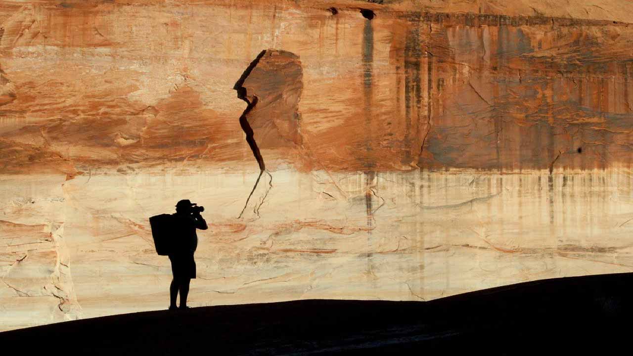 Photographer walking in a red canyon