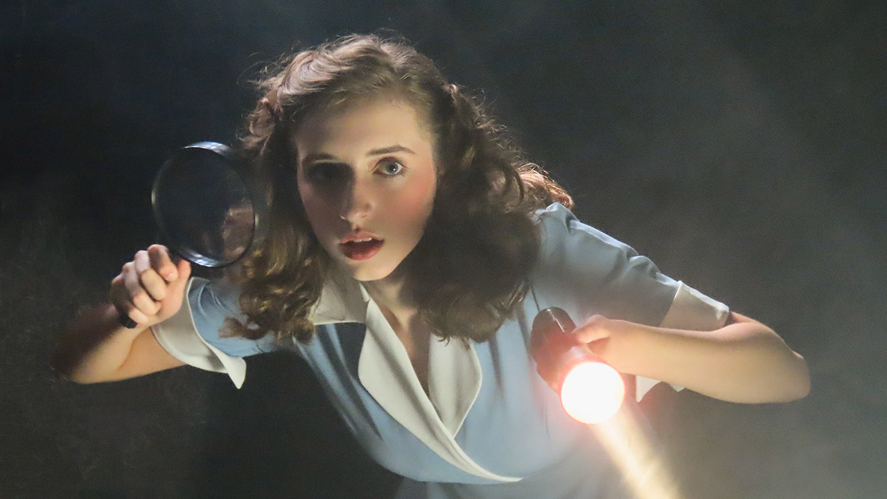 teen actress with magnifying glass and flashlight