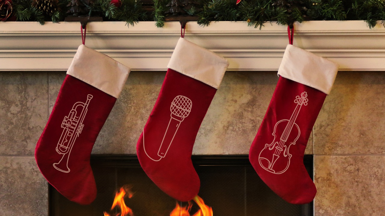 A fireplace with red stockings hanging from the mantel. The stockings have musical instruments on them.