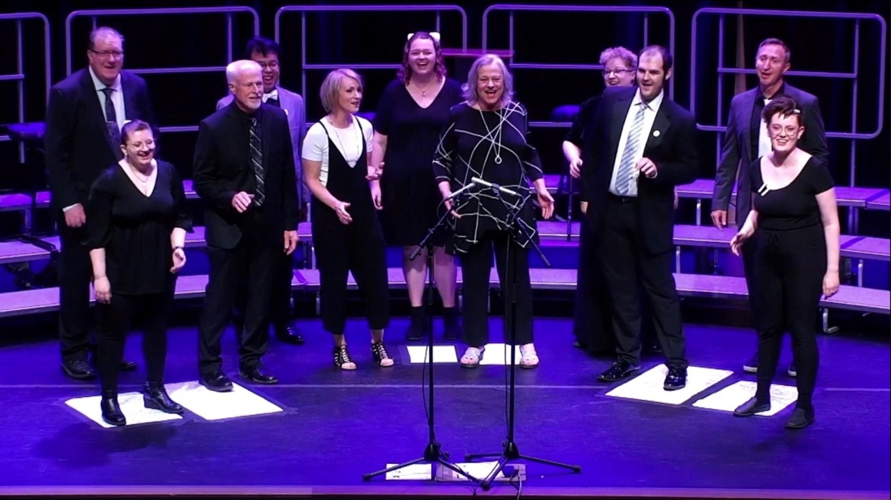 Performers standing on a stage and singing together