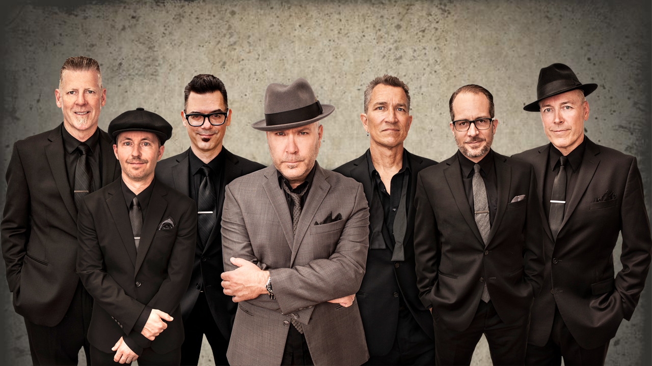 The band members of Big Bad Voodoo Daddy posed for a image, all wearing black suits