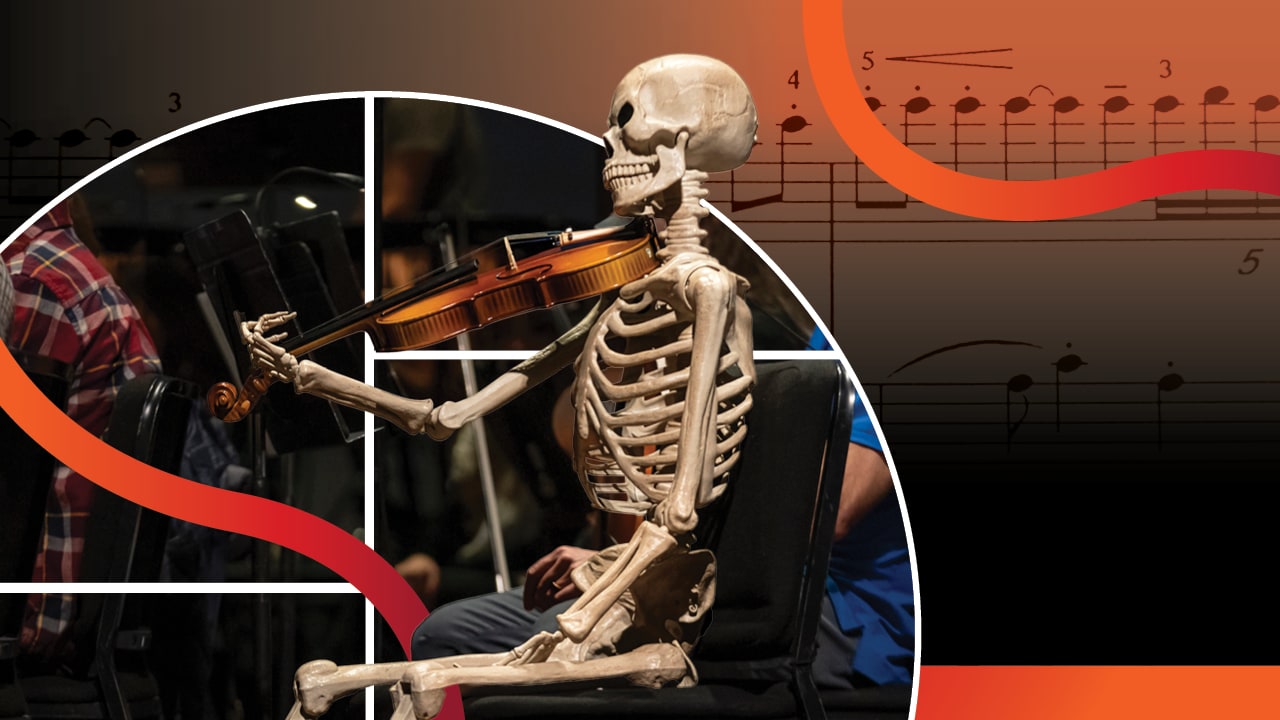 A skeleton holds a violin to its shoulder as if it is going to play it.