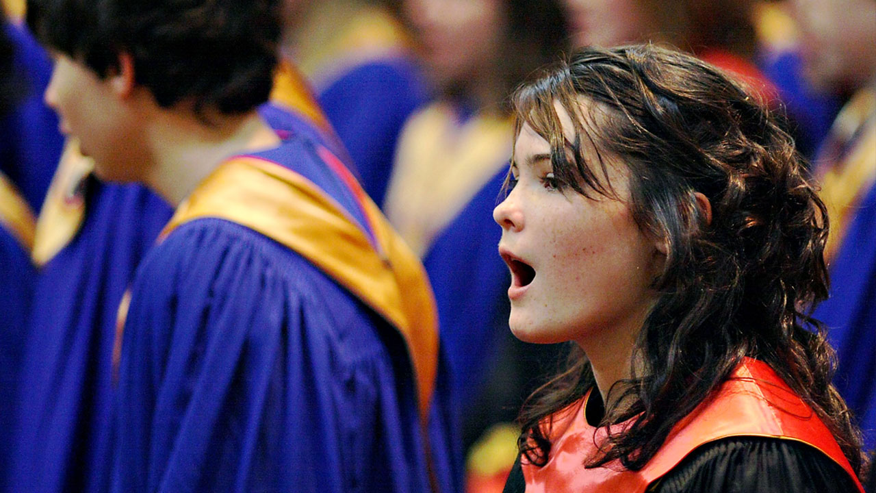 Student singing with choir robes on