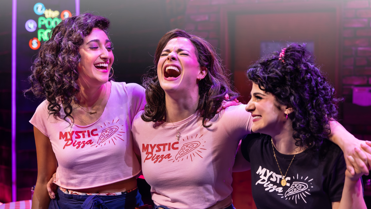 Image of the performers from Mystic Pizza on stage with their arms around each other laughing