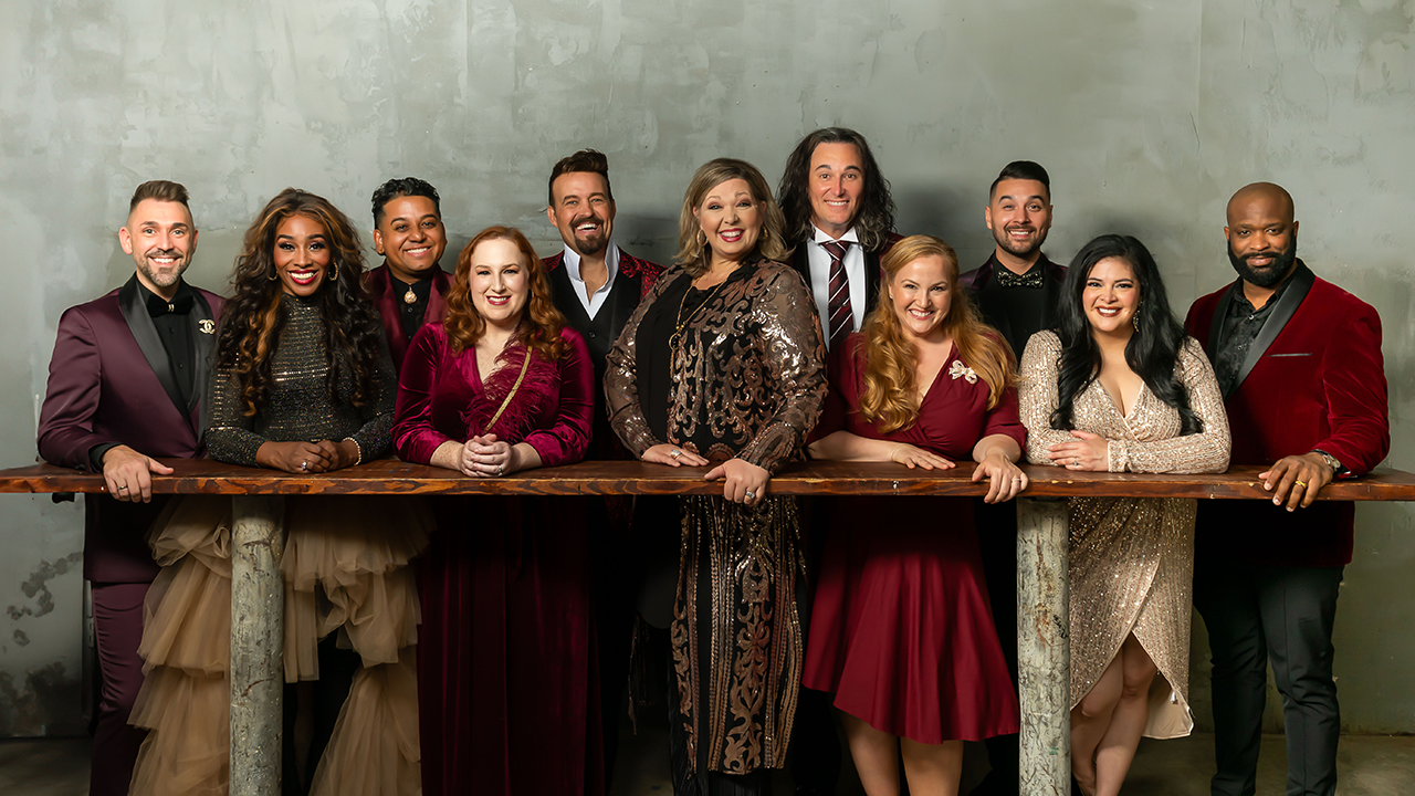 The group Voctave standing on one side of a tall table in "holiday red" formal wear